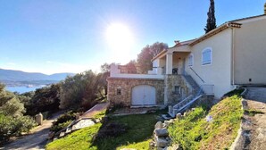 A two-story house with a stone entrance, a garage, and a balcony. - Super idyllic & antique villa with breathtaking sea view (Olmeto)