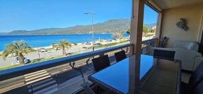 Enjoy the ocean views from this balcony with a glass-top table and comfortable seating for two.