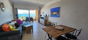 Relax in this inviting space with a sofa, dining table, and sea views.