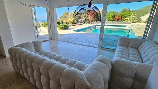 A spacious room with a large sliding glass door leading to a pool area. - Luxury villa Les Amandiers, sea view & swimming pool (Propriano)
