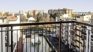 A residential building with multiple floors, balconies, and a parking area.