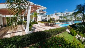 Um resort com piscina, área de estar externa e paisagismo exuberante.