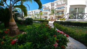 Um hotel com várias varandas, vegetação exuberante e um jardim bem cuidado.