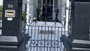 A black metal gate with a number "28" and a mailbox.