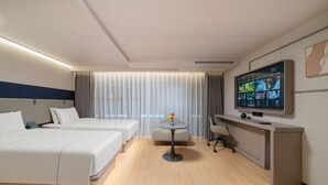 A hotel room with two beds, a desk, a chair, a TV, and a small table with a vase. - Beijing Yihai Culture Hotel (Beijing)