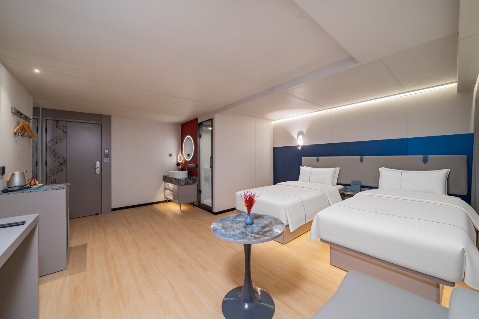 A hotel room with a bed, bedside tables, a desk, and a bathroom.