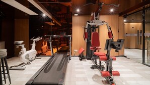 A modern gym with a treadmill, stationary bikes, and weight machines. - Beijing Yihai Culture Hotel (Beijing)