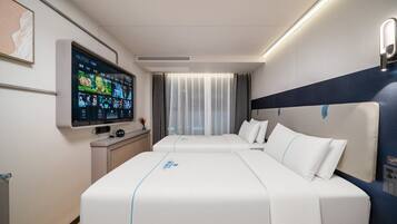Ein modernes Hotelzimmer mit einem großen Bett, einem Flachbildfernseher und einem Schreibtisch mit einem Computer.