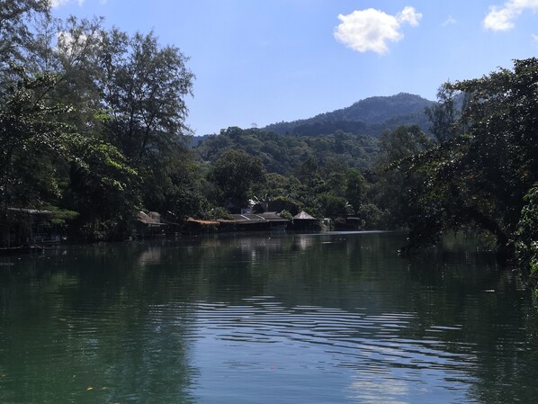 A calm lake surrounded by dense trees and a mountain in the background. - Iyara Boty Resort (Ko Chang)