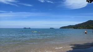 A beach with clear water, distant islands, and a forested hill. - Iyara Boty Resort (Ko Chang)