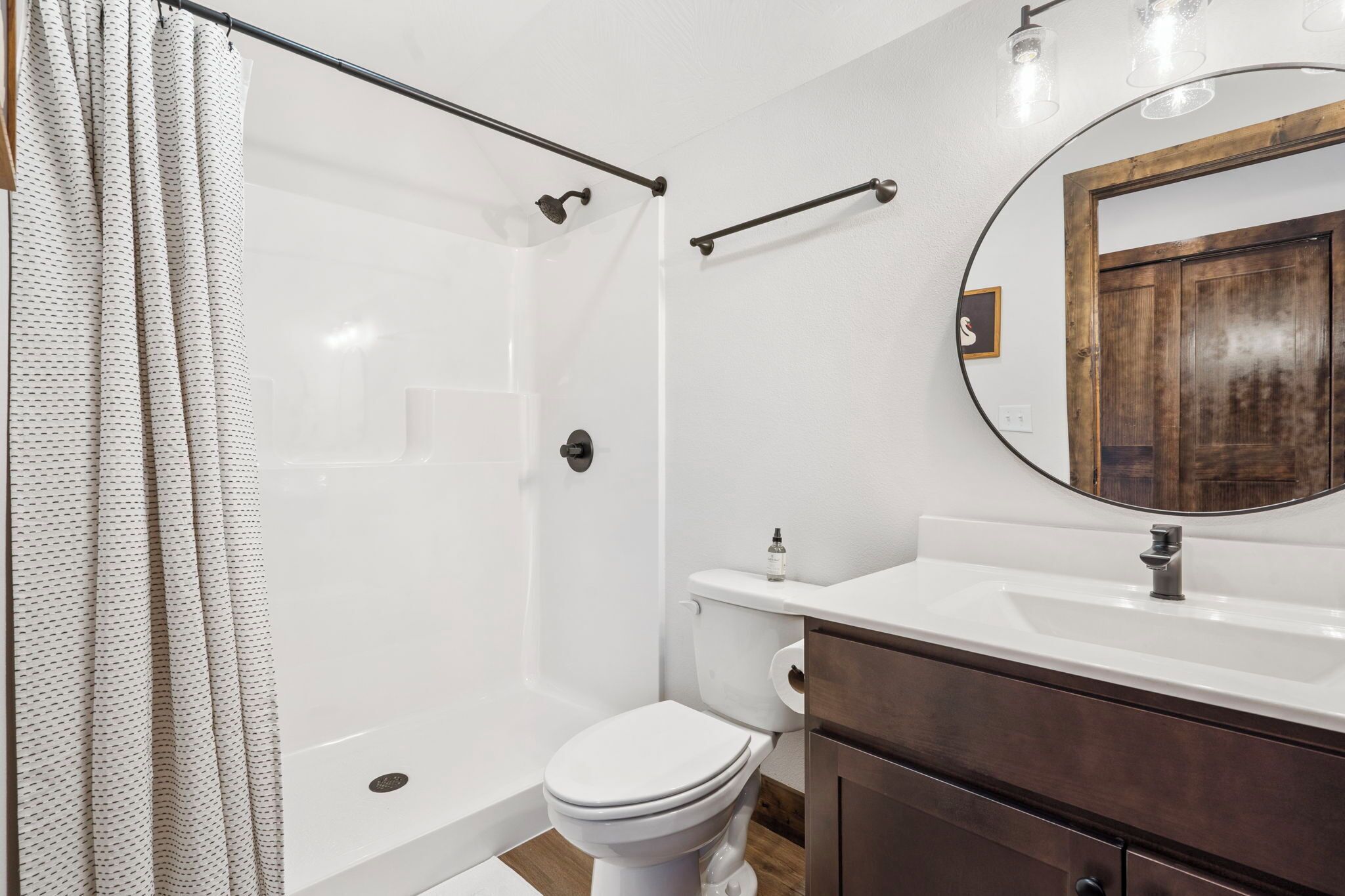 Une salle de bain moderne équipée d’une douche, de toilettes et d’un meuble-lavabo.