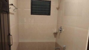 A small bathroom with a toilet, a shower, and a sink. - Hotel Alankar (Nagercoil)