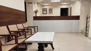 A conference room with a white table and wooden chairs. - Hotel Alankar (Nagercoil)