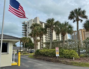 A hotel entrance with a flag, palm trees, and a 'No Trespassing' sign. - Direct oceanfront, corner balcony - amazing views ocean to river! On the beach!  (Fort Pierce)