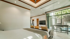 A modern hotel room with a large bed, a TV, and a balcony with a pool. - Rose Pool Villa, The perfect private oasis (Rawai)
