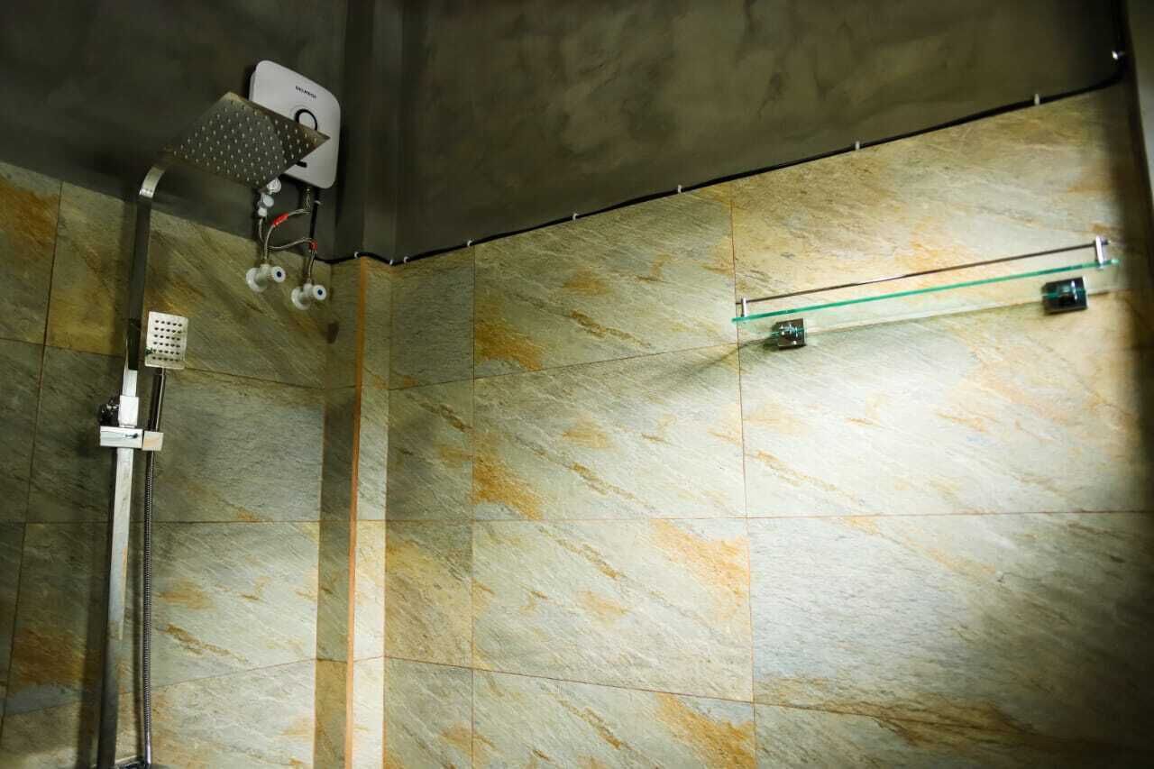 A shower with a handheld showerhead and a wall-mounted control panel.