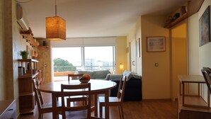 A modern kitchen with wooden furniture, a dining table, and a large window offering a city view. - Medas Park 261 - L'Estartit, Center (Estartit (L´))