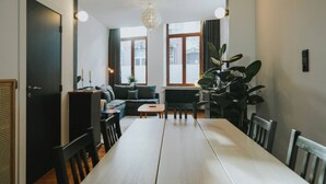 A modern living room with a dining table, sofa, and large windows. - 2 bedroom apartment in Liege (Saint Leonard) (Liège)