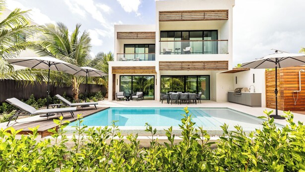 A modern two-story house with a swimming pool, outdoor seating, and a wooden fence. - Lotus Villas #1-Leeward Palms. Your Gateway to Paradise & Step into Serenity.... (Leeward Settlement)