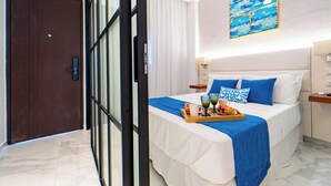 A hotel room with a bed, a breakfast tray, a painting, and a door. - Refugio Ideal Golf & Piscina Cana Rock Star (Bavaro)