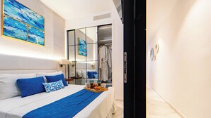 A hotel room with a bed, a bedside table, a mirror, a wardrobe, and a breakfast tray.