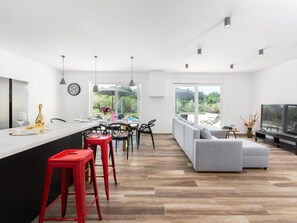 Relax in this stylish living space with a fully equipped kitchen, dining area for four, and a comfortable sofa.