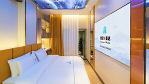 A hotel room with a bed, a ceiling projection of space, and a wall-mounted screen displaying hotel branding. - Dequan Luxury WangJing Hotel (Beijing)