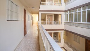 A multi-level corridor with balconies, doors, and windows. - Fuente de Piedra Apartment (Torre Del Mar)