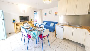 Un espace de vie compact comprenant un coin repas, une kitchenette et un canapé.