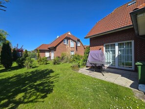 Een woonwijk met twee bakstenen huizen, een gazon en een overdekte patio tafel.