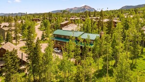 A lodge with multiple cabins surrounded by dense forest, a clear sky, and a mountain in the background. - Silverthorne Retreat | Pet Friendly + Trail Access (Silverthorne)