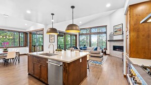 Una cocina amplia con una isla central, ventanas grandes y una chimenea.
