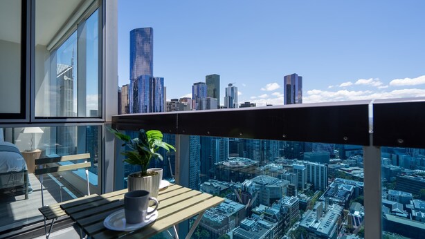 A balcony with a city view, a table with a plant, and a chair. - lvl42 2B APT with Free Parking in Melbourne CBD (Melbourne)
