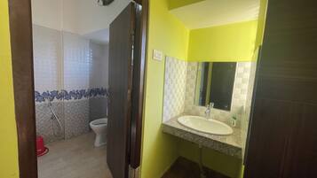 Une salle de bain avec des toilettes, une douche et un lavabo.