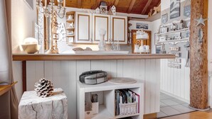 A kitchen with white cabinets, a wooden ceiling, and various kitchen items on the counter.