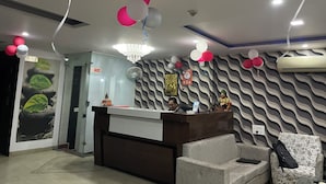 Un área de recepción con mostrador, sillas y un muro con diseño.