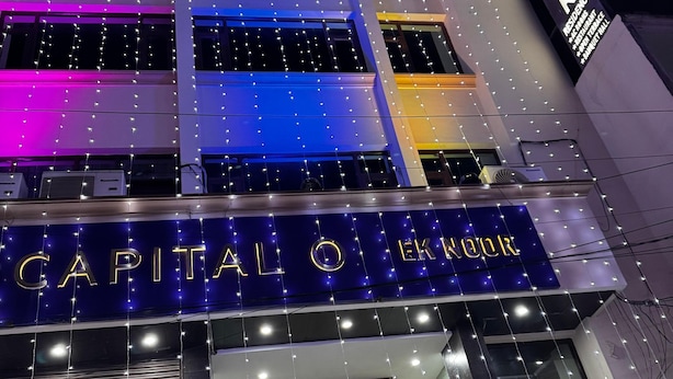 Un hotel con un cartel que dice "CAPITAL Q HOTEL" y "EK ZOO".