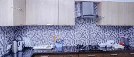A modern kitchen with wooden cabinets, a tiled backsplash, and stainless steel appliances.