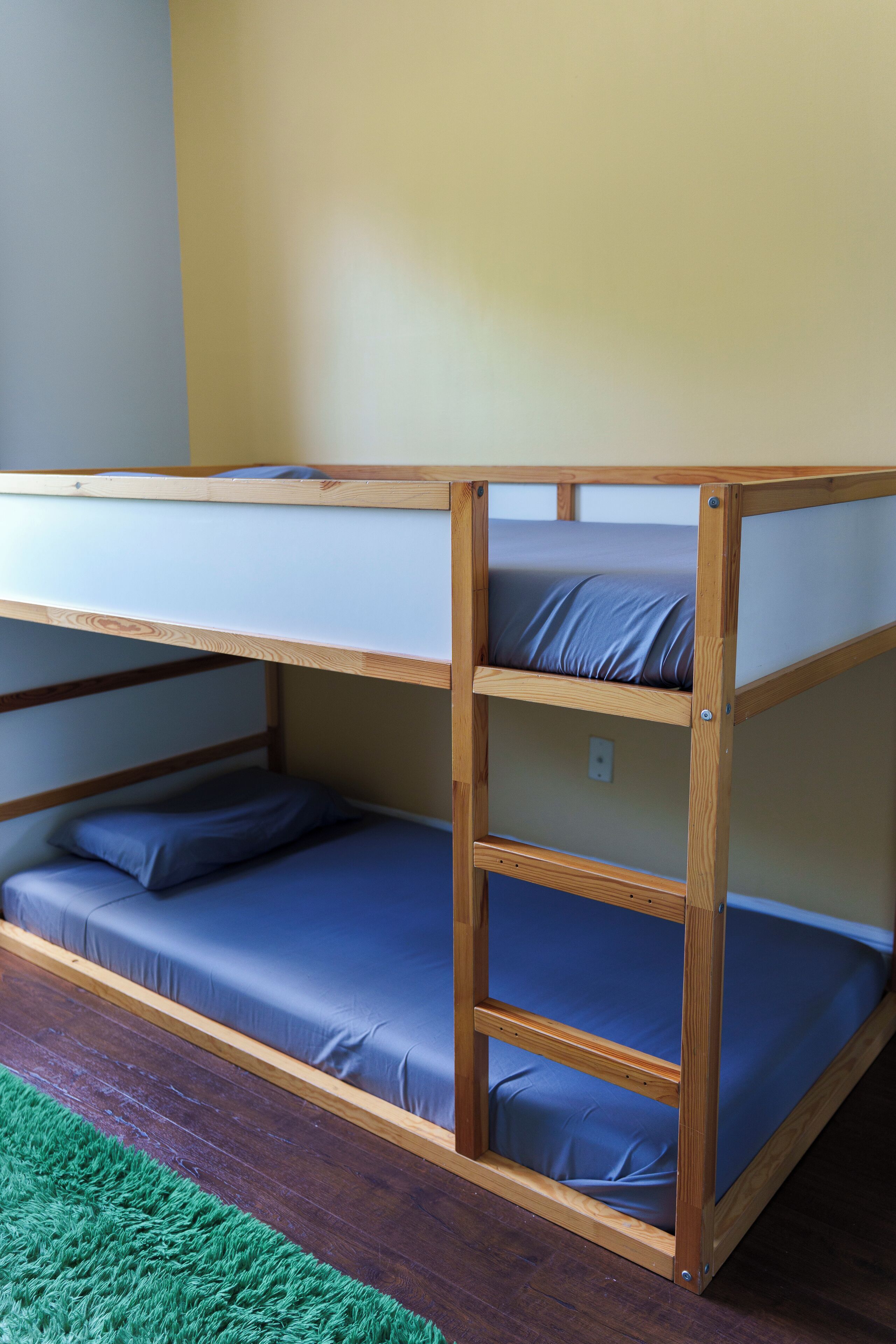 Un lit superposé à deux niveaux, chaque niveau étant équipé d’un matelas et d’oreillers.