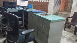 Una oficina pequeña con un escritorio, computadora y silla de oficina.