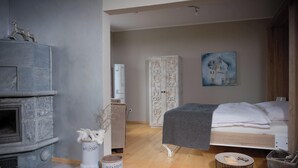 Une chambre à coucher avec un lit, une cheminée, une armoire et un tableau au mur.