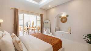 A modern hotel room with a large bed, a dining area, and a view of the city. - Luxe Stunning 3BR Villa in Canggu, 8 mins to beach (Canggu)