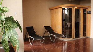 Un vestíbulo con dos sillones negros, un mostrador de recepción de madera y una planta en maceta.