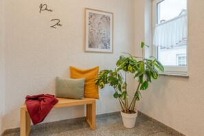 Relax in a serene space with a wooden bench, potted plant, and framed artwork.