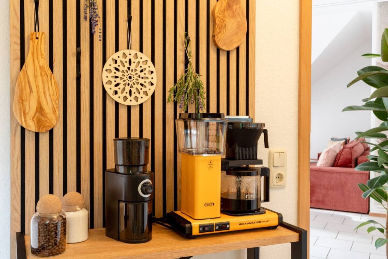 Eine Küchenarbeitsplatte mit Kaffeemaschine, Mixer und einer weiteren Kaffeemaschine.
