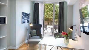 A modern living room with a sofa, a dining table, and a TV. - Bendix weaving mill, junior apartment, 1-3 persons (Dülmen)