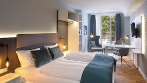 A modern hotel room with a large bed, bedside tables, a desk, and a chair. - Bendix weaving mill, junior apartment, 1-3 persons (Dülmen)