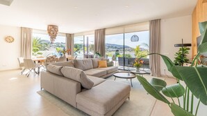 A modern living room with a sofa, coffee table, and dining area. - Casa Amorosa by Solidays - Moraira, Costa Blanca (Moraira)
