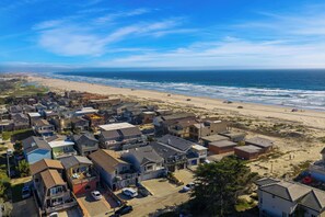 A coastal residential area with houses, a beach, and the ocean.