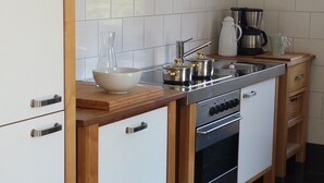 Cozinha compacta com pia, fogão e cafeteira.